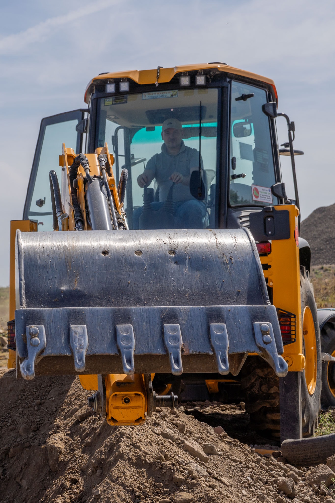 After editing: the same front loader with recovered detail in the driver, cab, yellow bodywork, metal bucket and ground